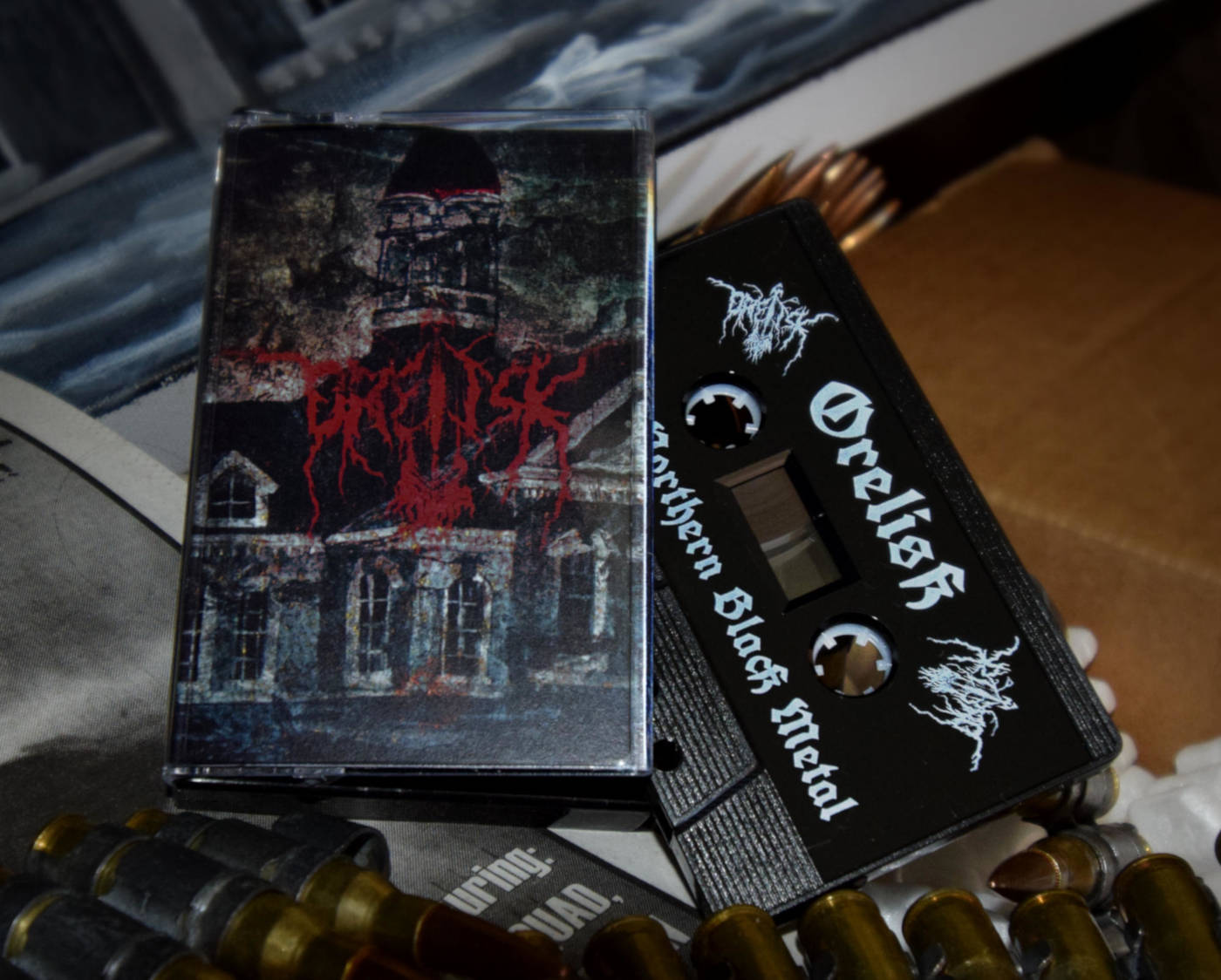 Band brand logo for Orelisk in blood red with dark surreal background on cassette tape. Logo and editing by Korpi.